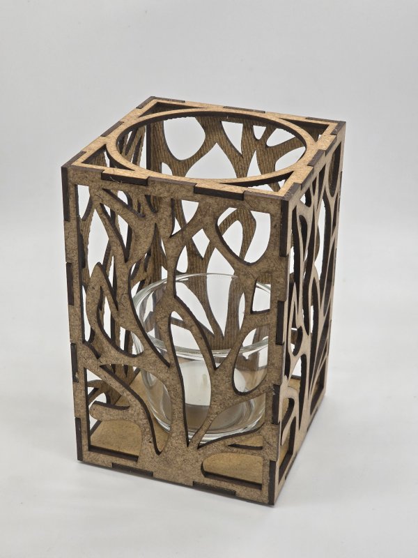 Ljuslyktan Eld i natur – handgjord trälykta med utskuret eld-motiv som sprider ett varmt och levande ljus. Tillverkad i Sverige av Nordland Design.