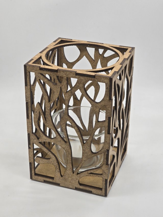 Ljuslyktan Eld i natur – handgjord trälykta med utskuret eld-motiv som sprider ett varmt och levande ljus. Tillverkad i Sverige av Nordland Design.