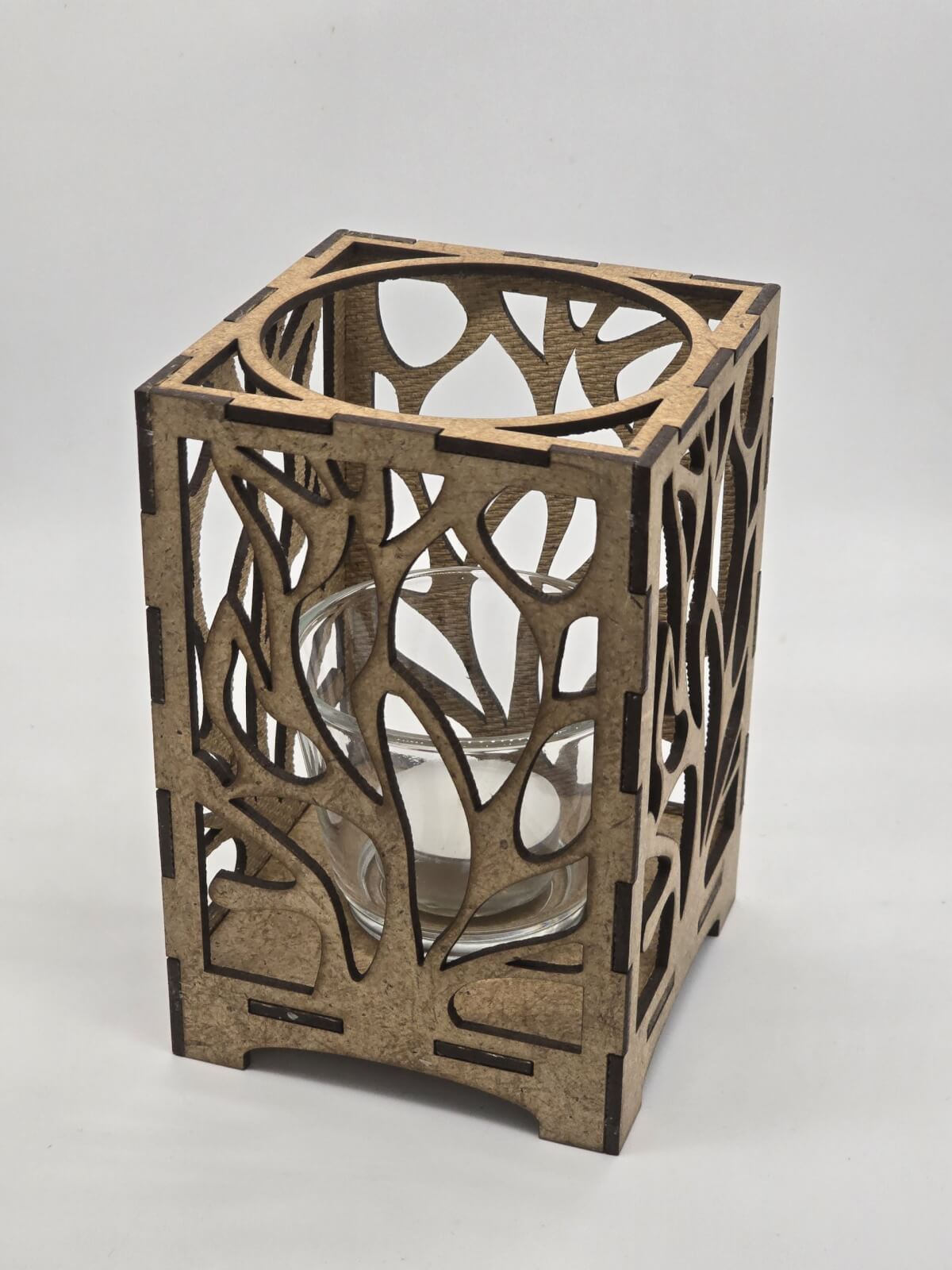 Ljuslyktan Eld i natur – handgjord trälykta med utskuret eld-motiv som sprider ett varmt och levande ljus. Tillverkad i Sverige av Nordland Design.