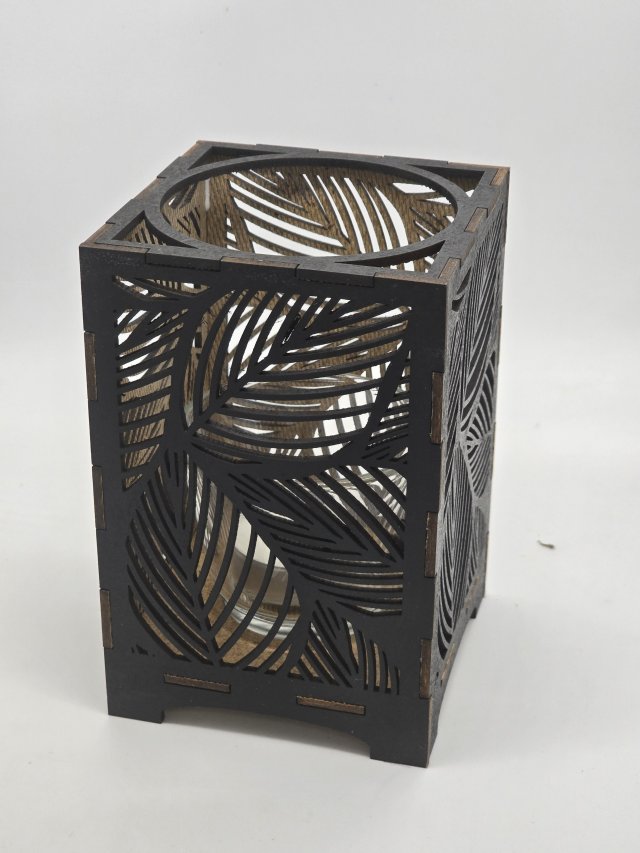 Ljuslyktan Saga i svart – handgjord trälykta med lövmotiv som ger ett elegant och stämningsfullt ljus. Tillverkad i Sverige av Nordland Design.