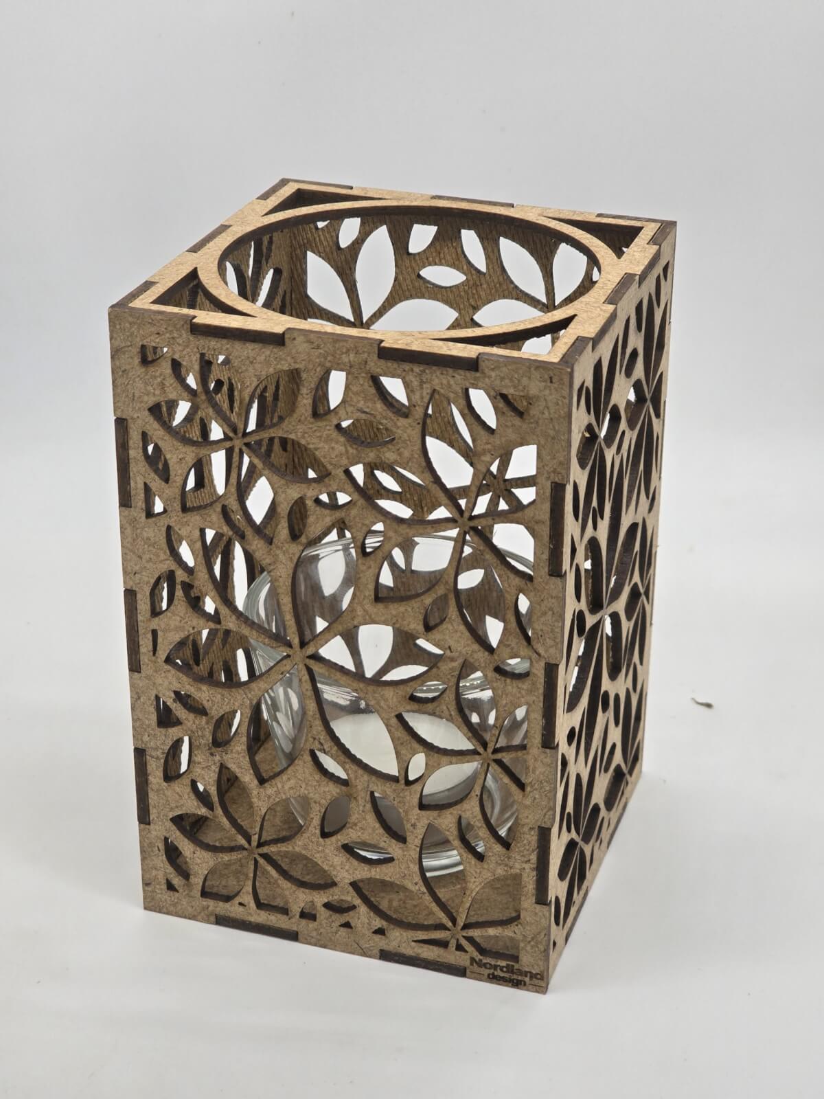 Ljuslyktan Lily i natur – handgjord trälykta med frostinspirerat mönster som sprider ett mjukt och stämningsfullt ljus. Tillverkad i Sverige av Nordland Design.